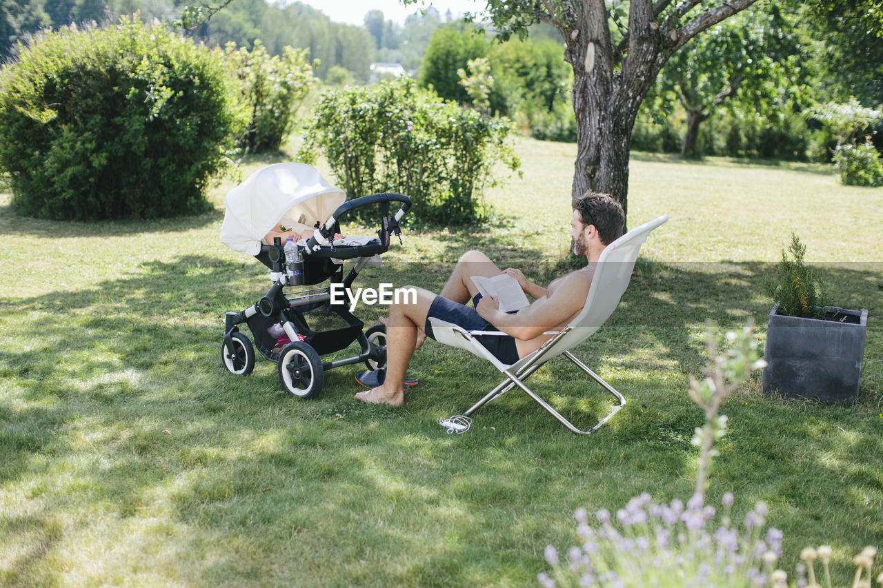 Father in garden with child in buggy