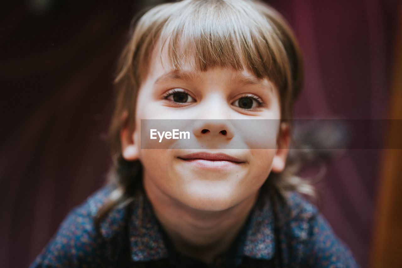 Portrait face cute happy smiling candid little kid boy blond hair looking up camera home lifestyle