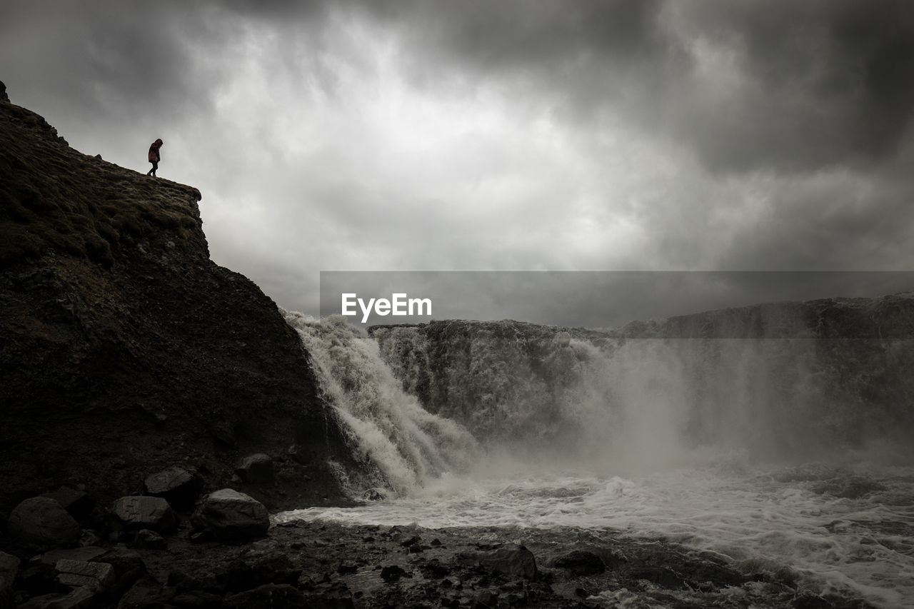 Scenic view of waterfall against sky