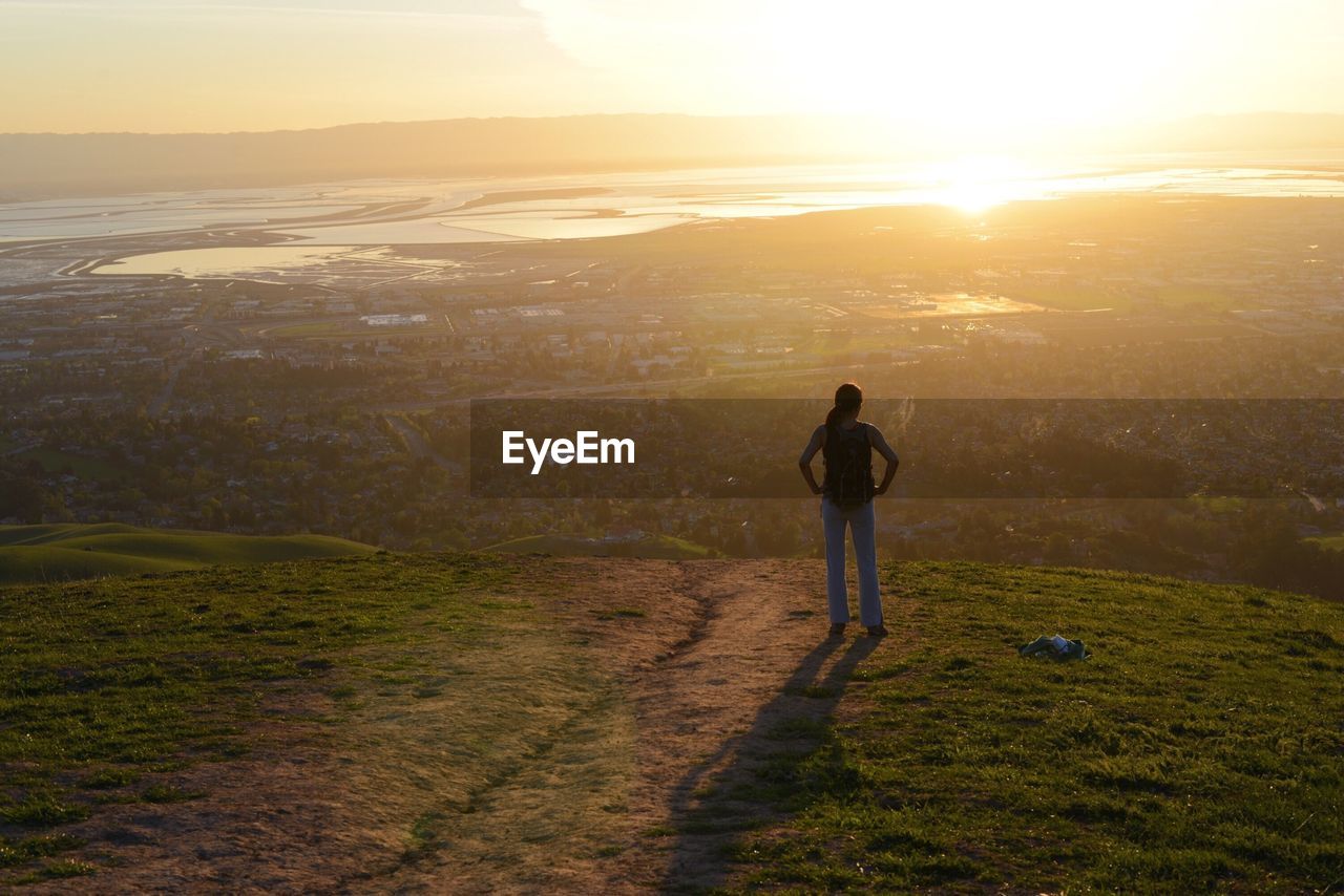 Person looking at sunset over landscape