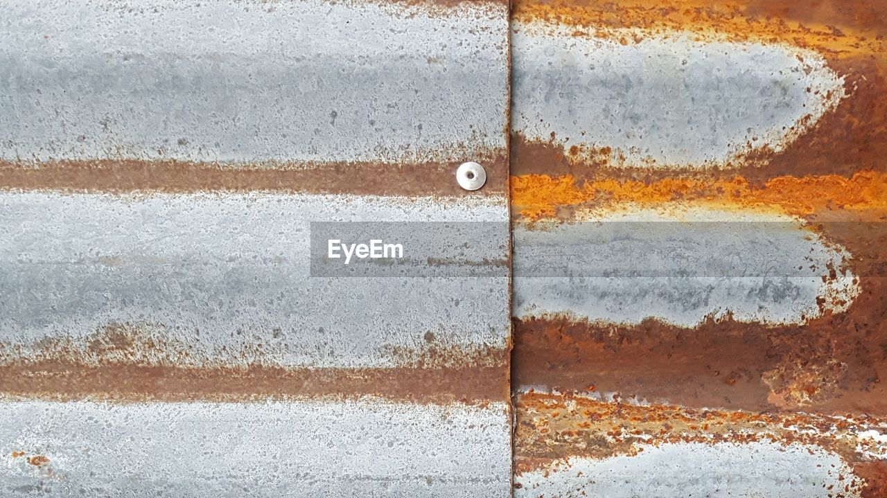 FULL FRAME SHOT OF WEATHERED WALL WITH METAL