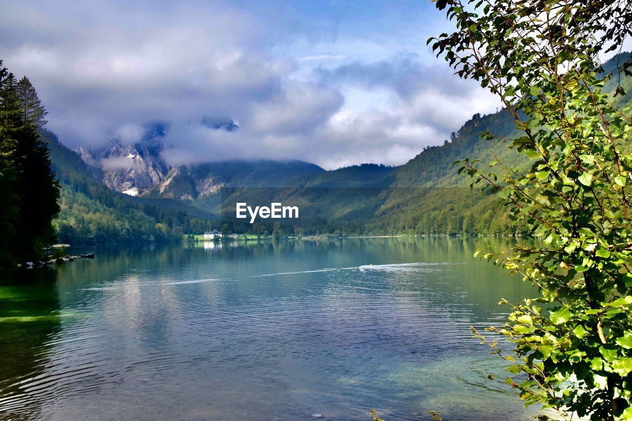 Scenic view of lake and mountains against cloudy sky