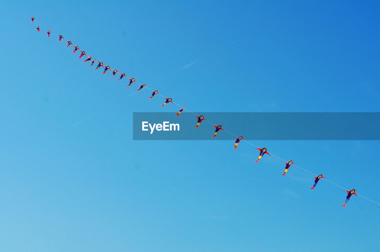 LOW ANGLE VIEW OF AIRSHOW AGAINST CLEAR SKY