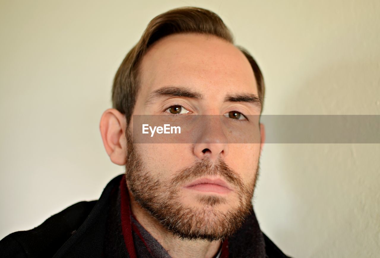 Close-up portrait of man against wall