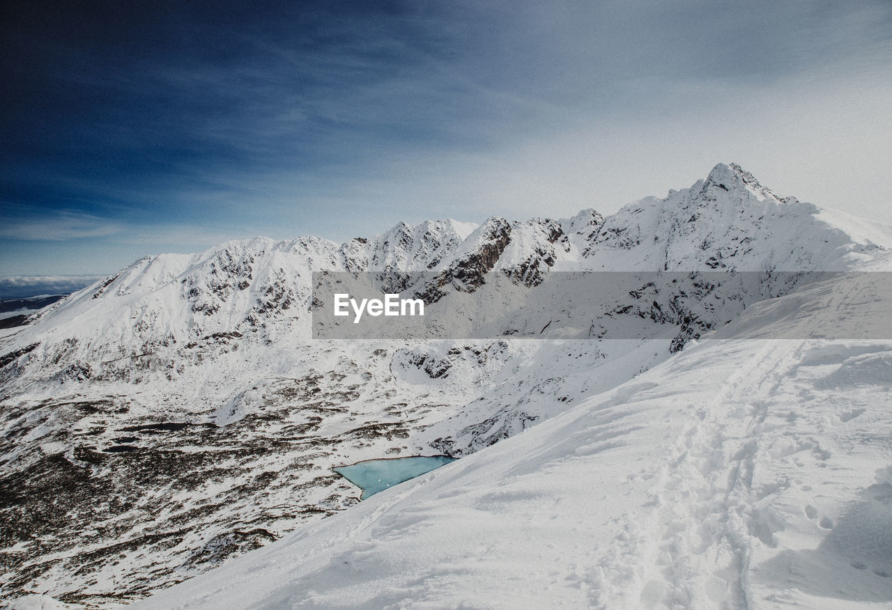 AERIAL VIEW OF SNOW ON LANDSCAPE AGAINST SKY