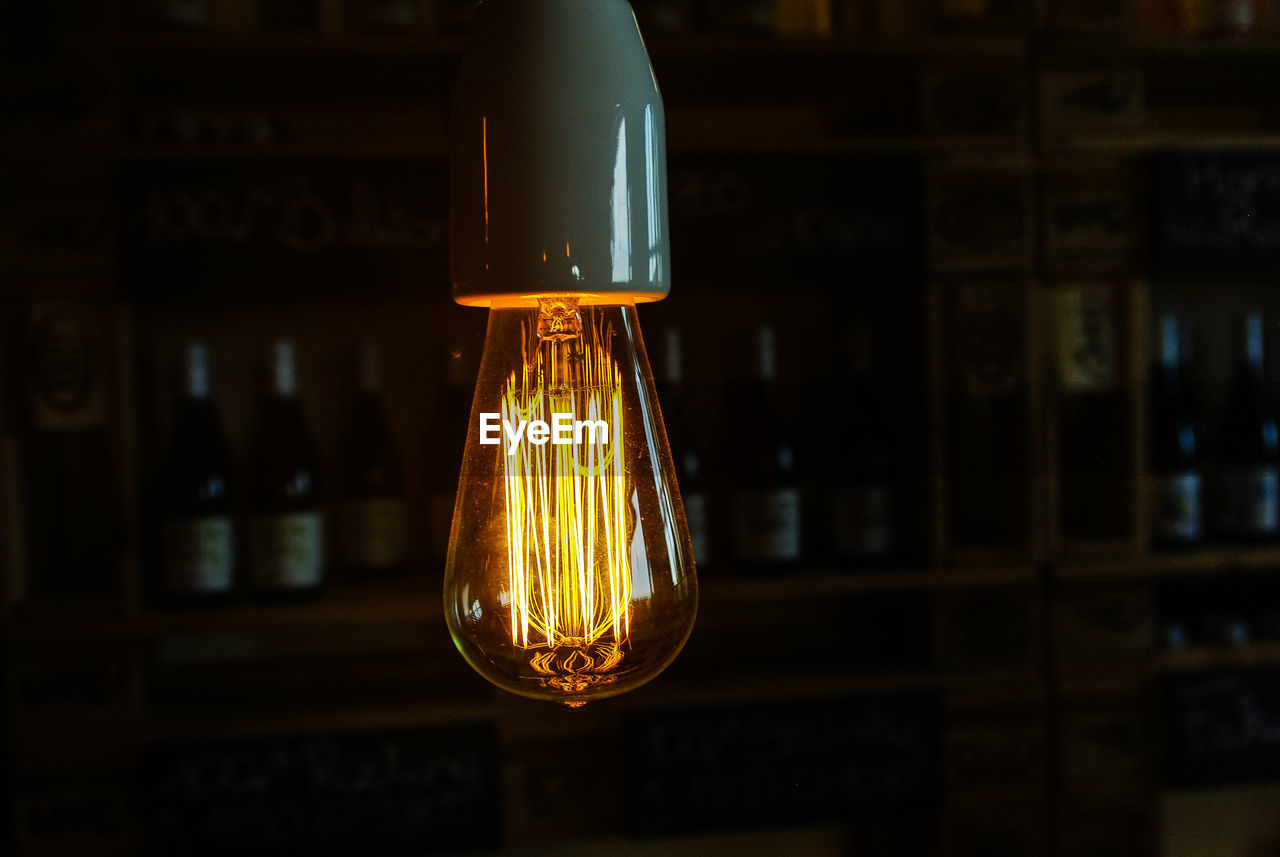 Close-up of lit light bulb against blurred background