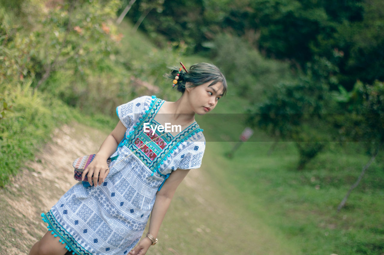 portrait of young woman standing on grassy field