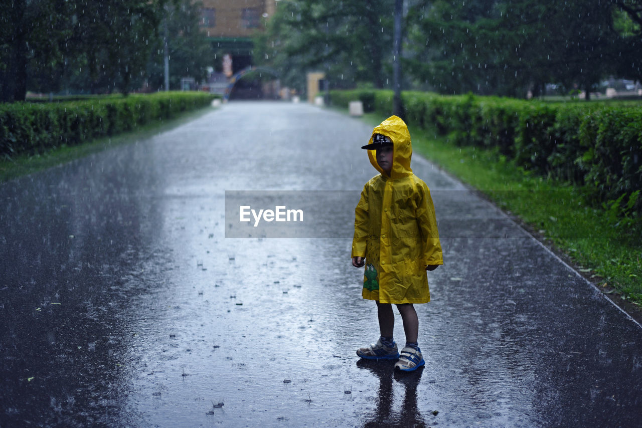 Full length of boy in yellow raincoat