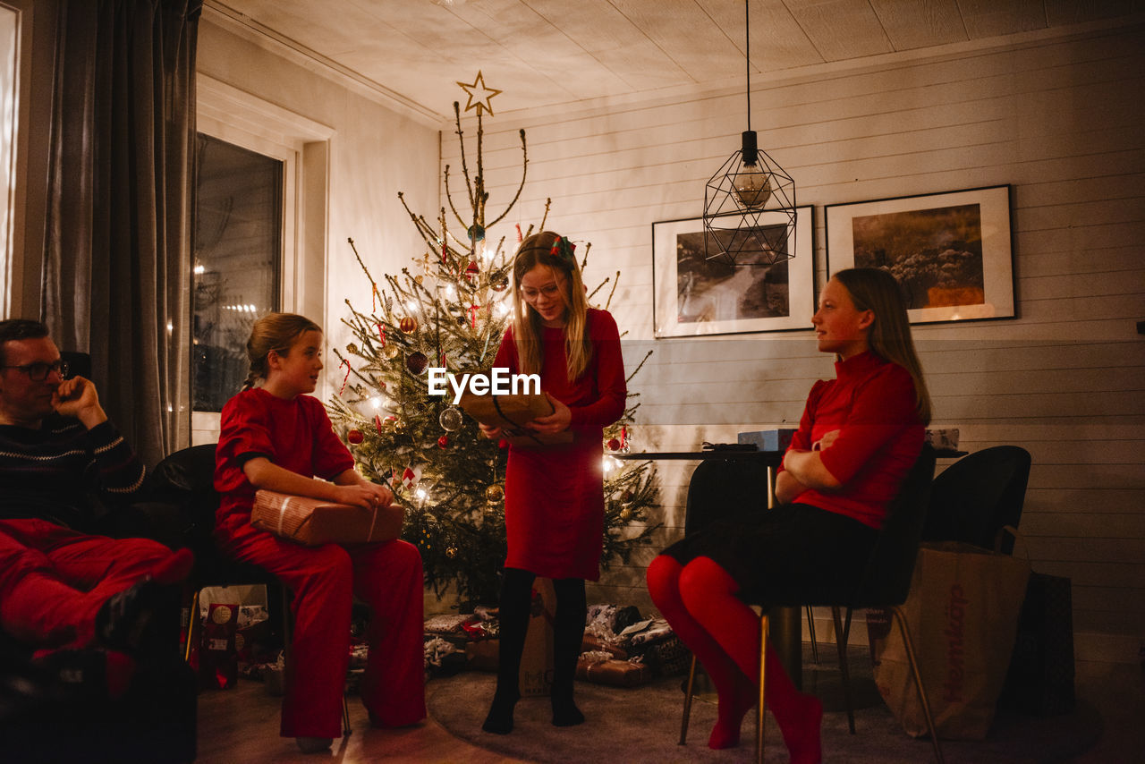 Father and daughters opening christmas presents