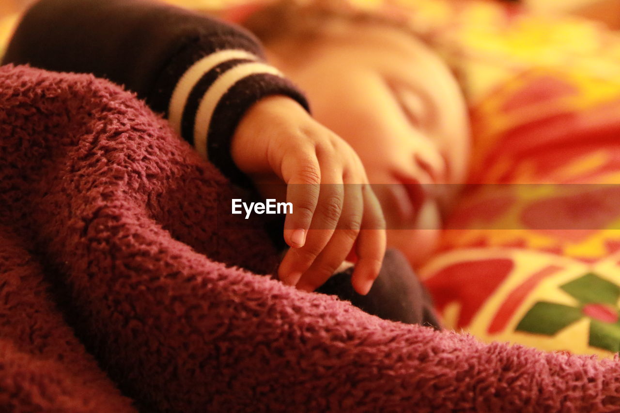 Close-up of baby sleeping on bed