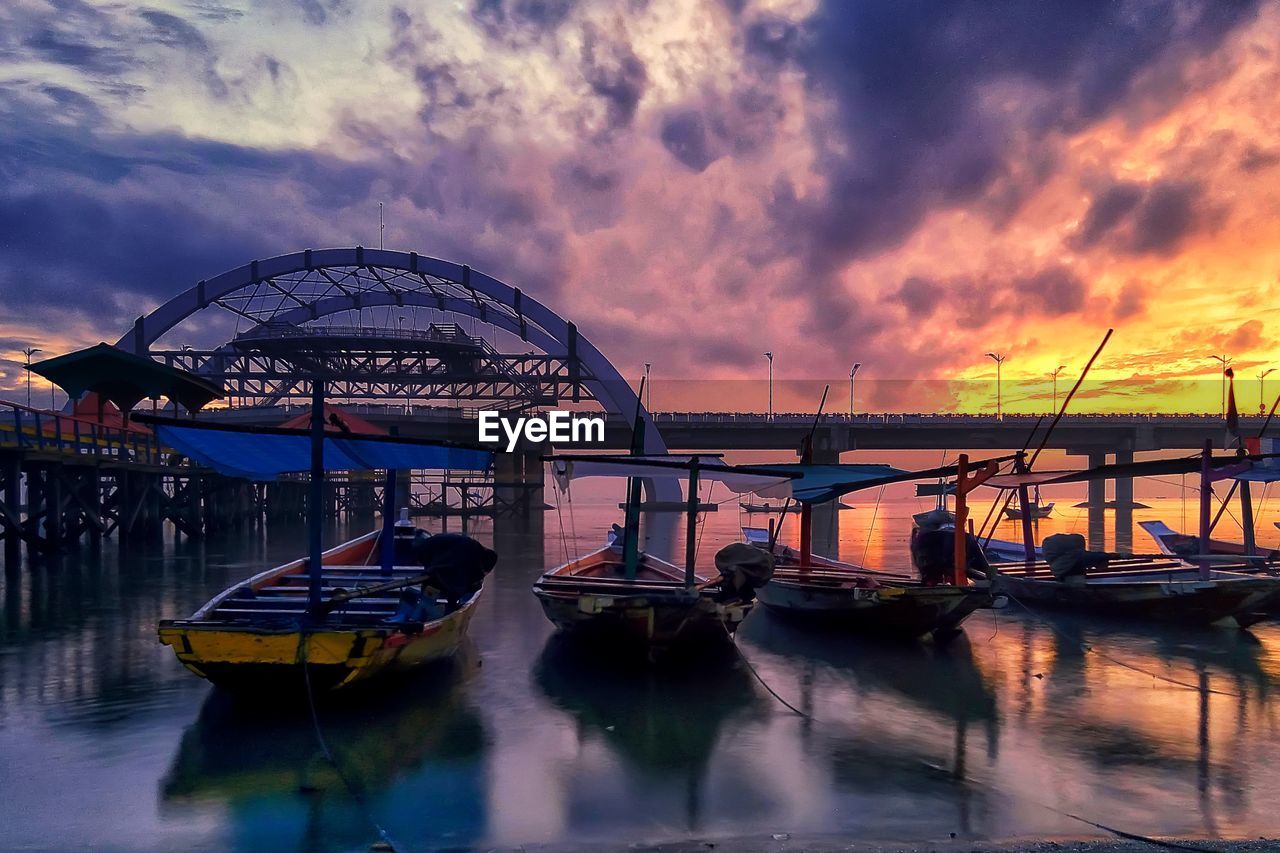 BOATS MOORED AT SEA AGAINST SKY