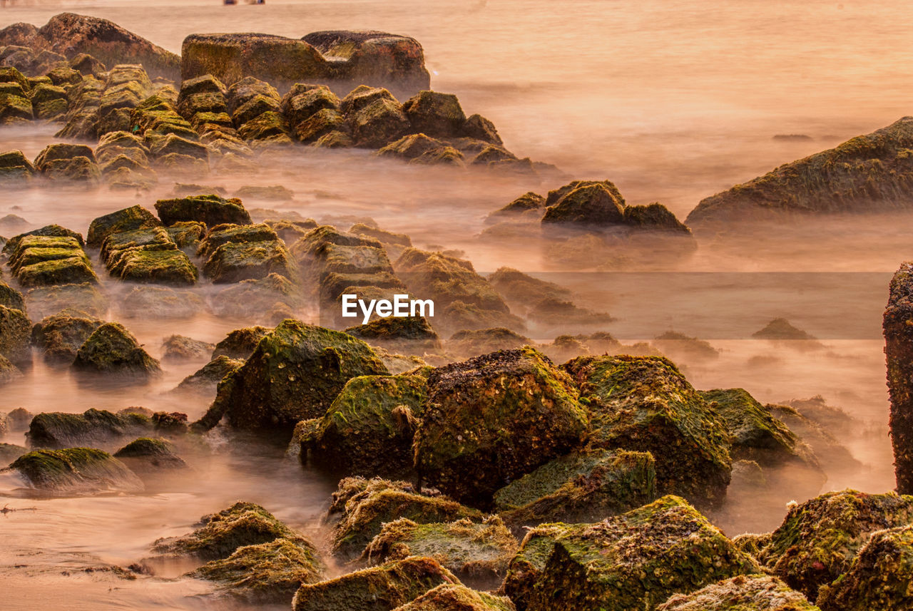 Scenic view of rocks in sea against sky