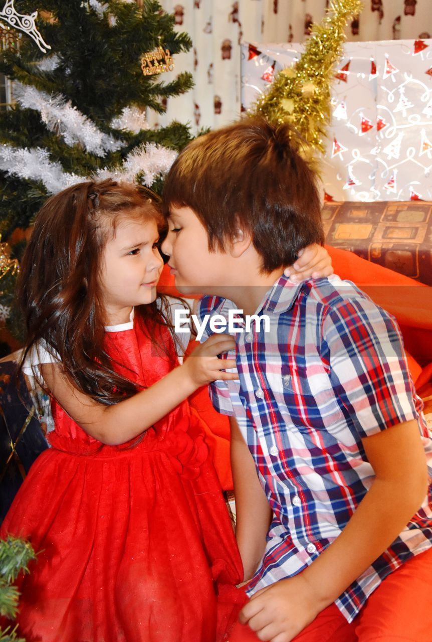 Cute siblings face to face at home during christmas