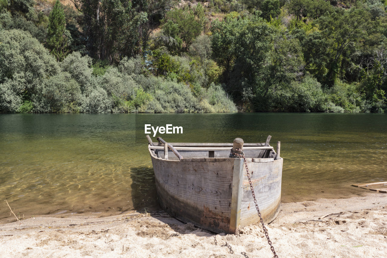 Boat moored on shore by lake