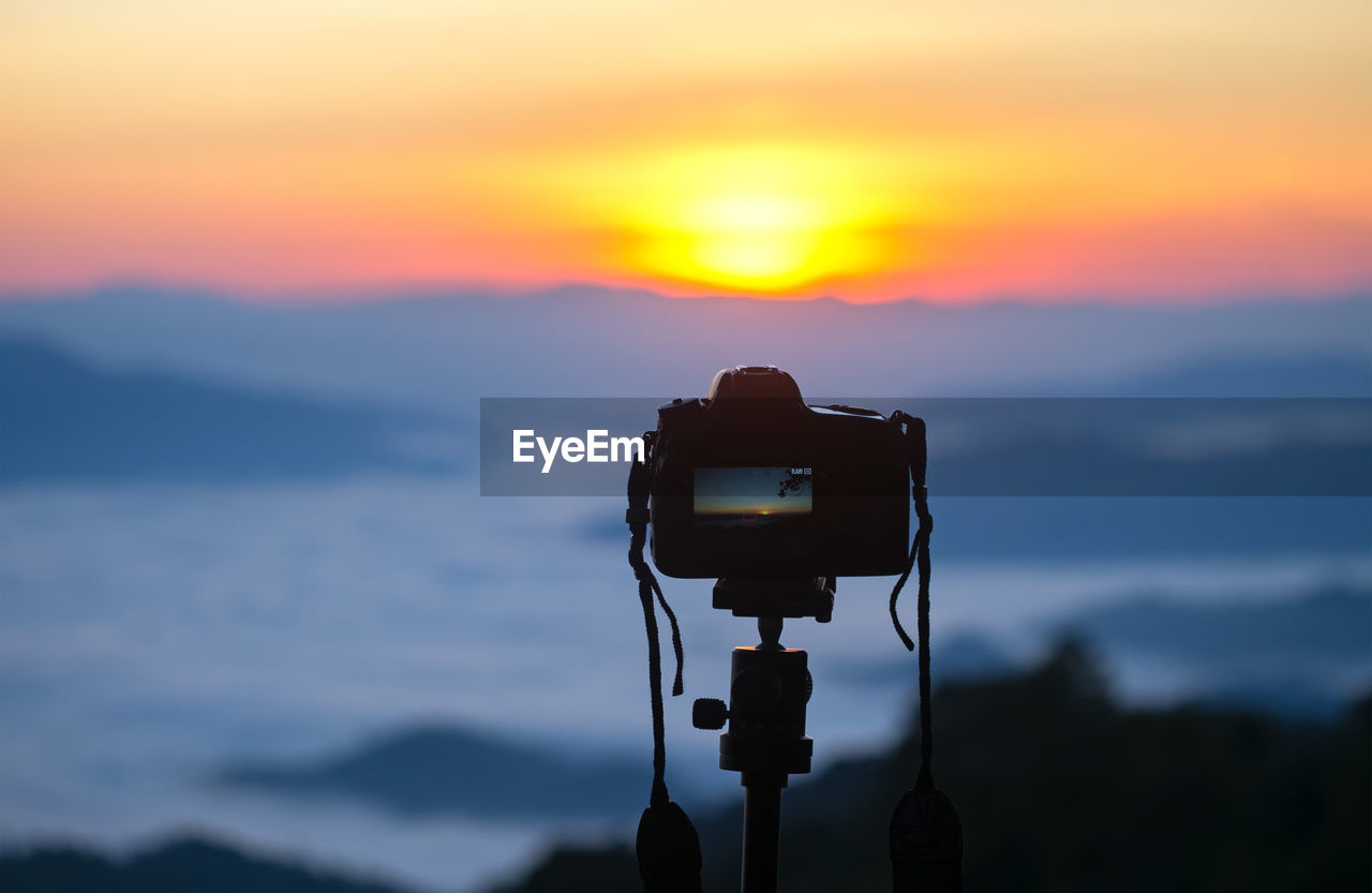 CAMERA AGAINST ORANGE SKY