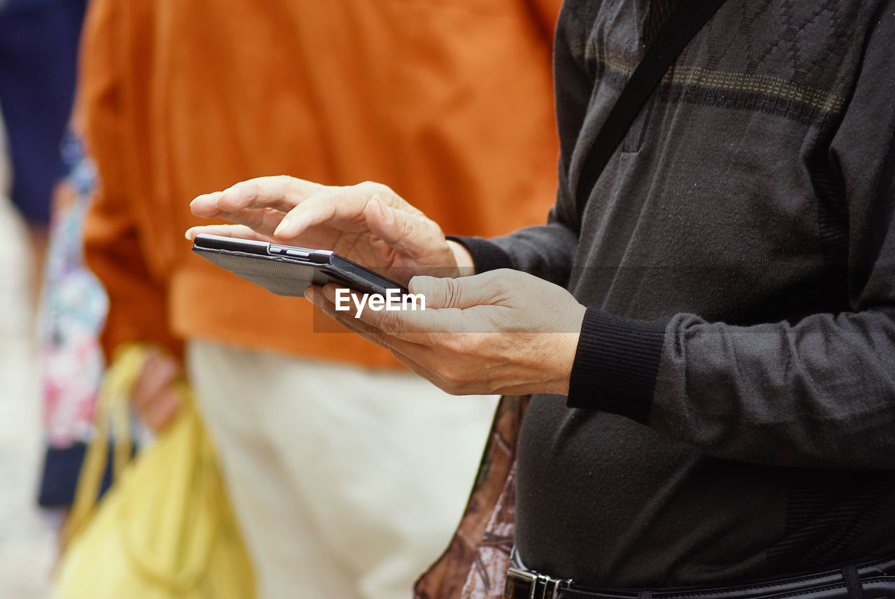 Midsection of man using mobile phone