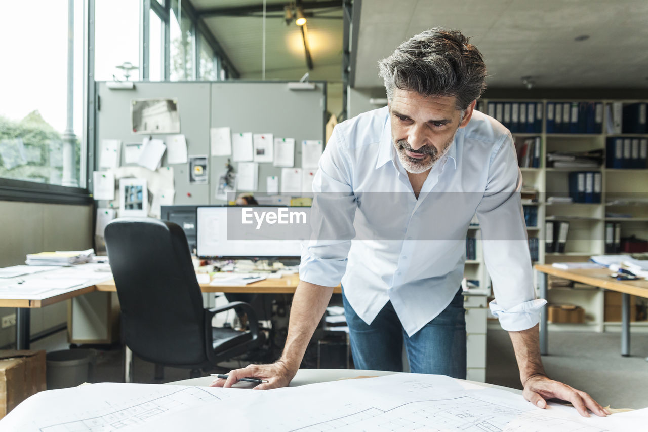 Architect working on ground plan in office