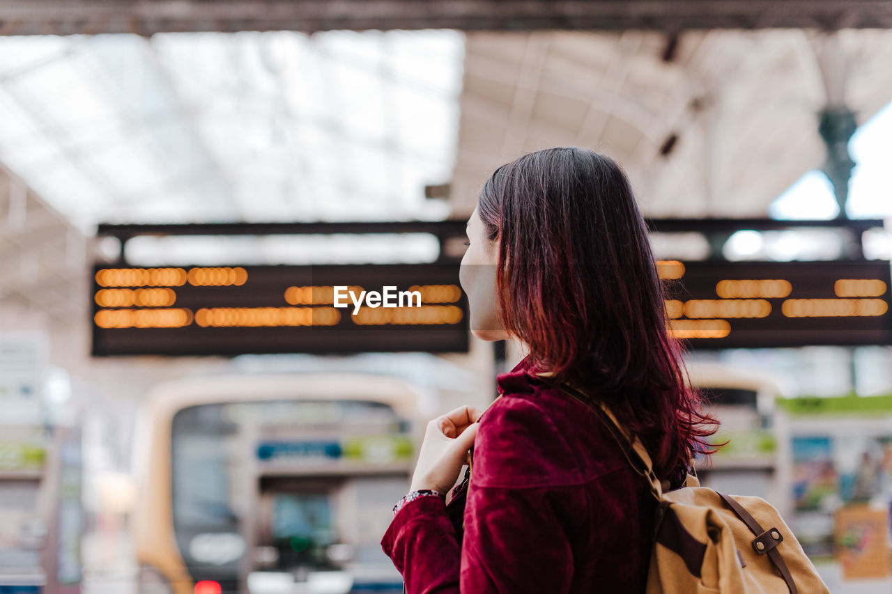 Woman standing at railroad station