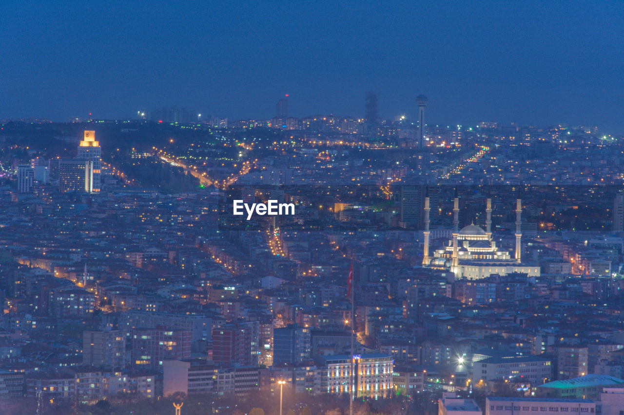 High angle view of city lit up at night