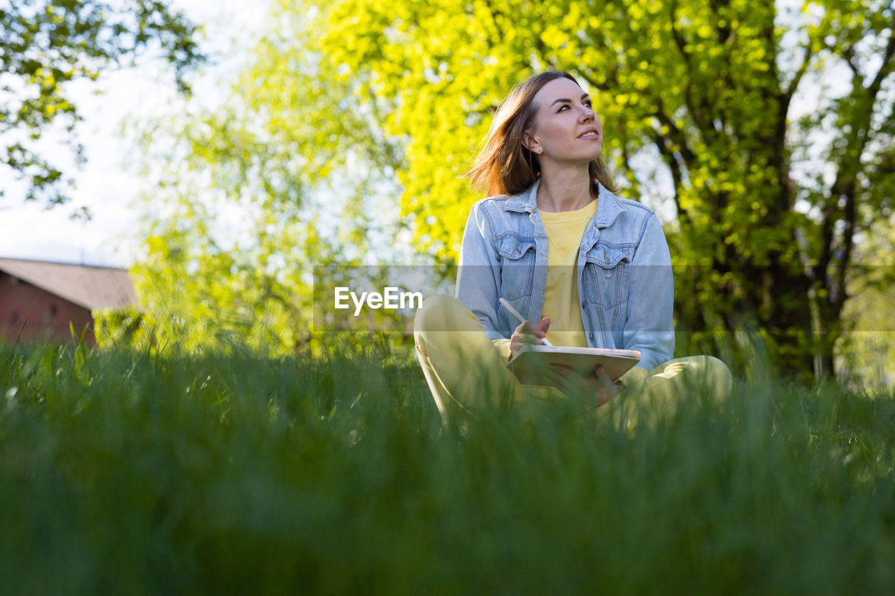 portrait of young woman sitting on field