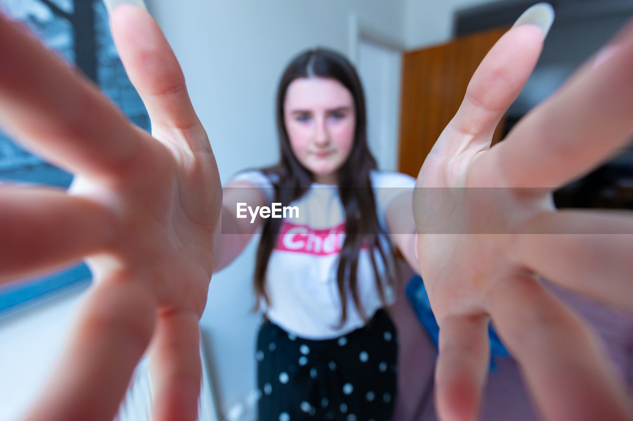 CLOSE-UP PORTRAIT OF A WOMAN STANDING IN A HANDS