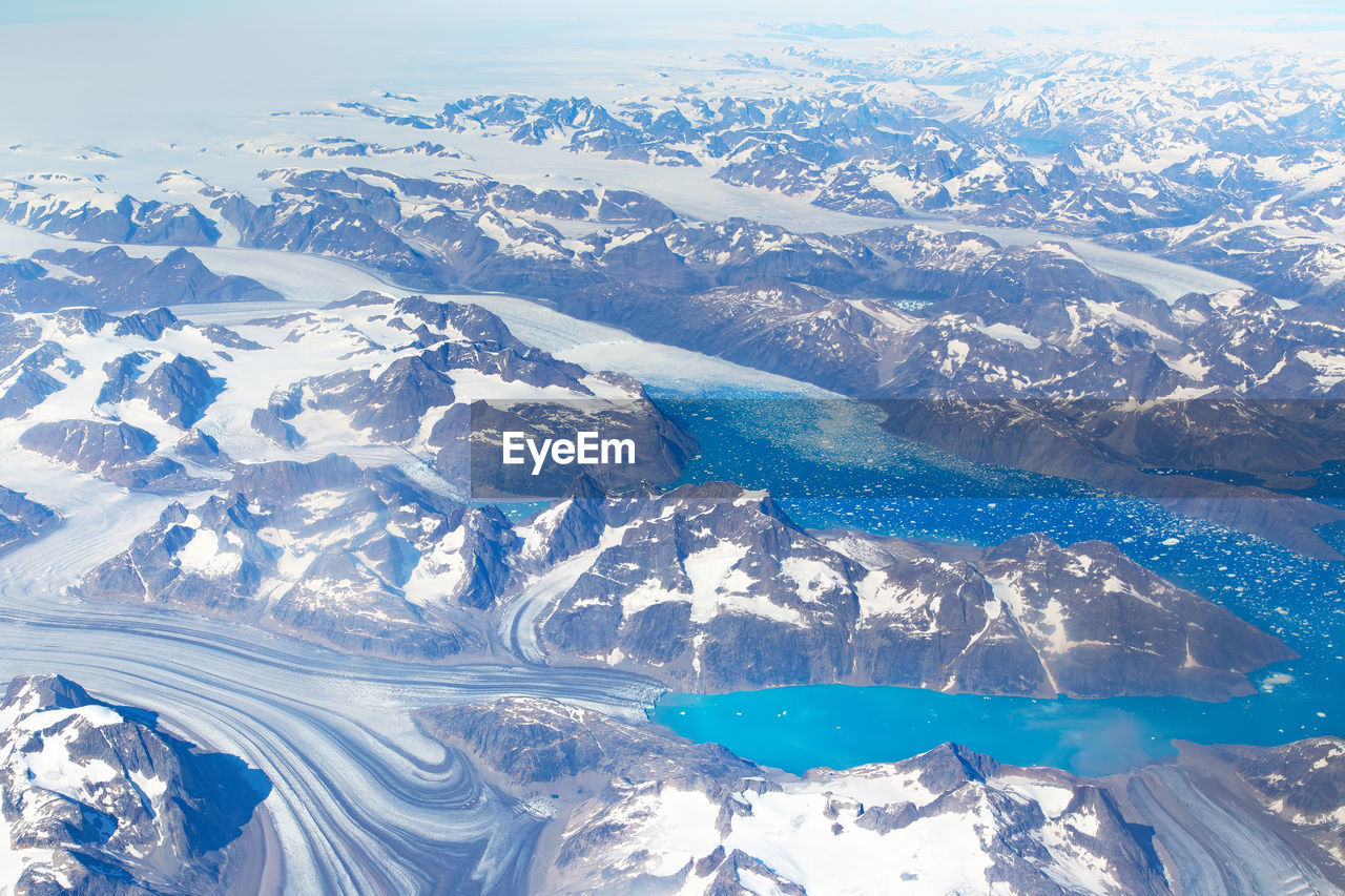 HIGH ANGLE VIEW OF SNOWCAPPED MOUNTAINS AND SEA