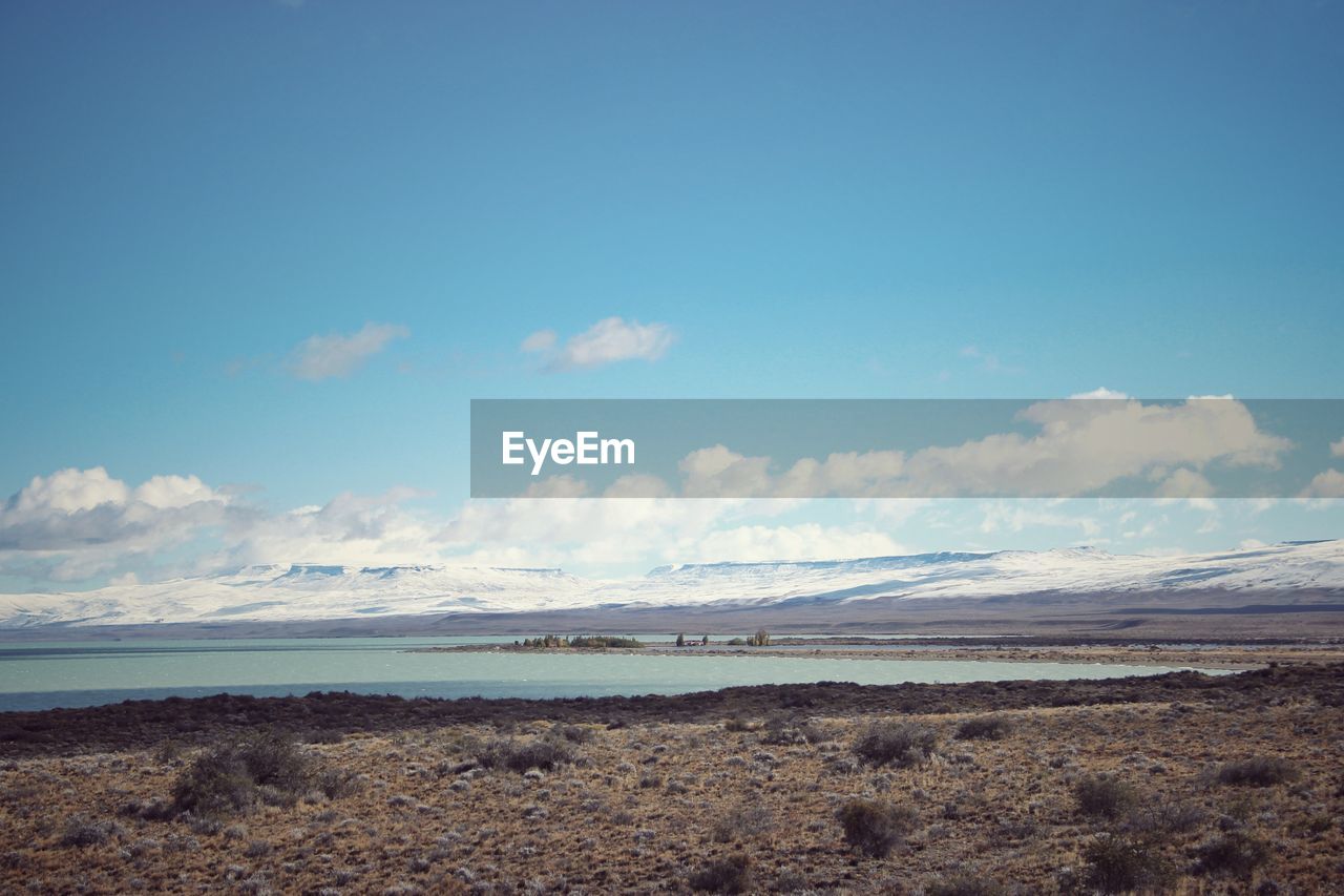 Scenic view of beach against blue sky