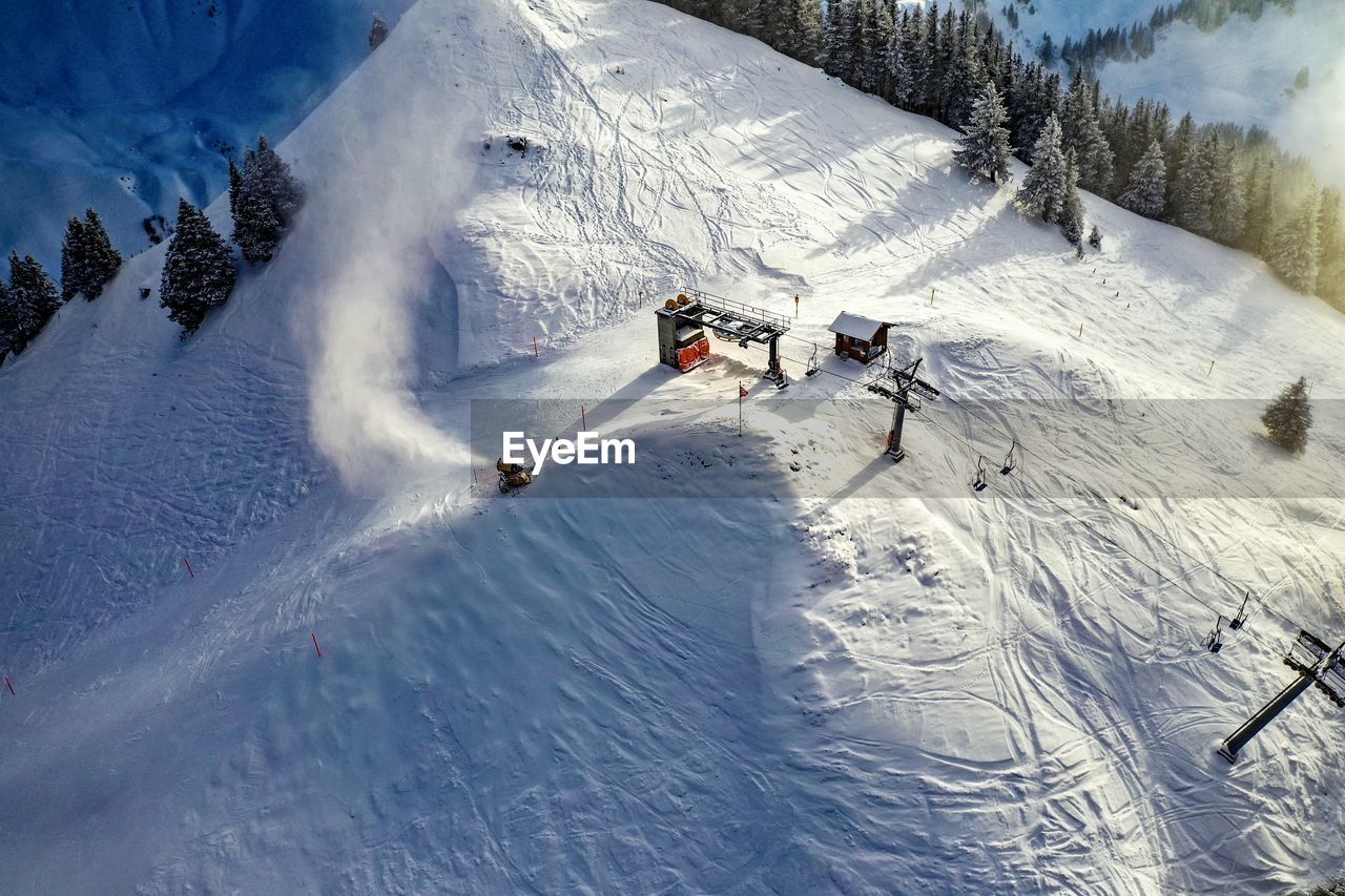 PEOPLE SKIING ON SNOW COVERED MOUNTAIN