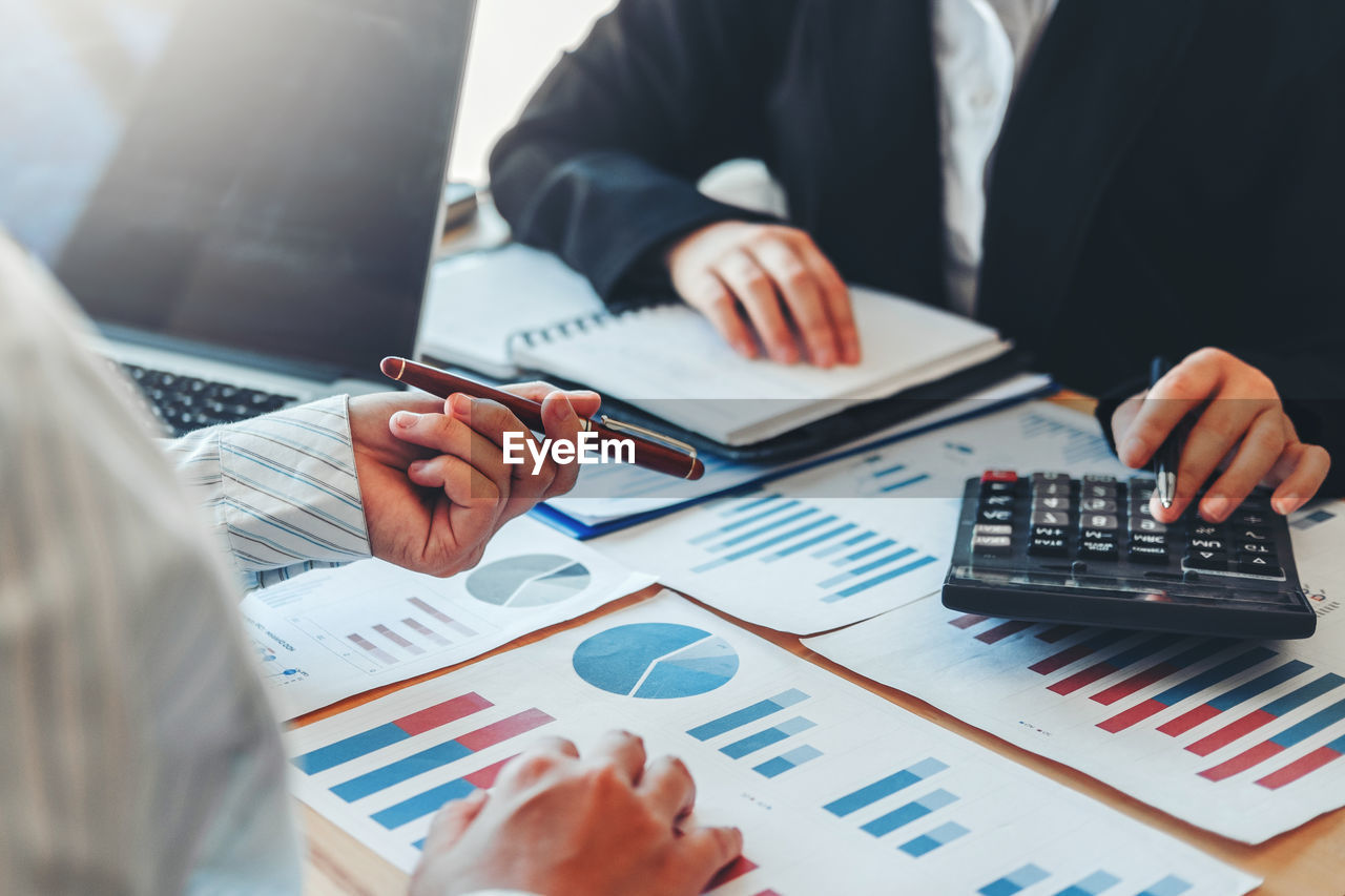 Cropped image of business colleagues working at desk in office