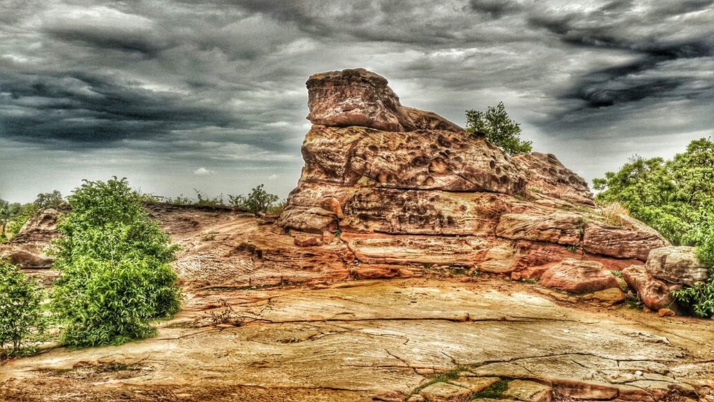 SCENIC VIEW OF ROCK FORMATIONS AGAINST CLOUDY SKY