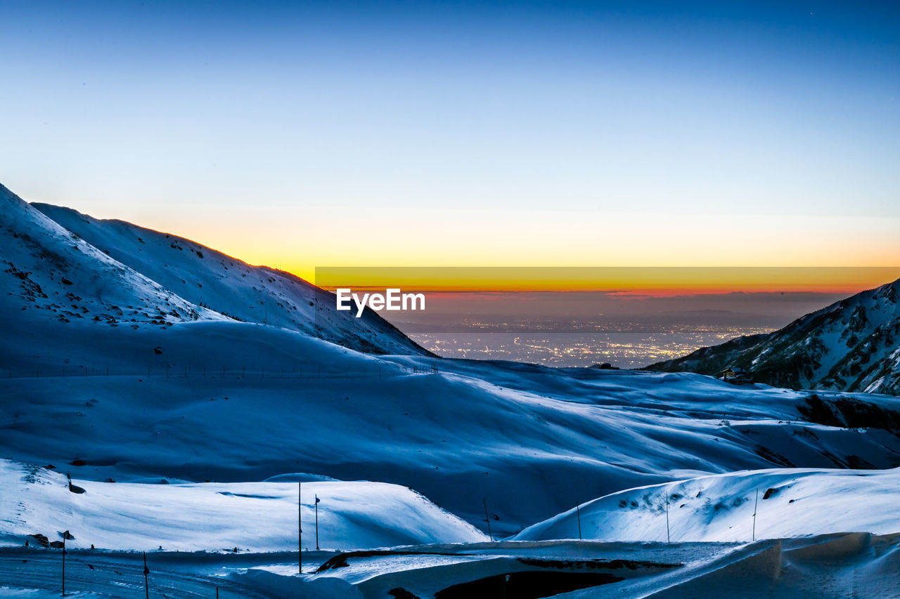 SNOW COVERED LANDSCAPE AT SUNSET