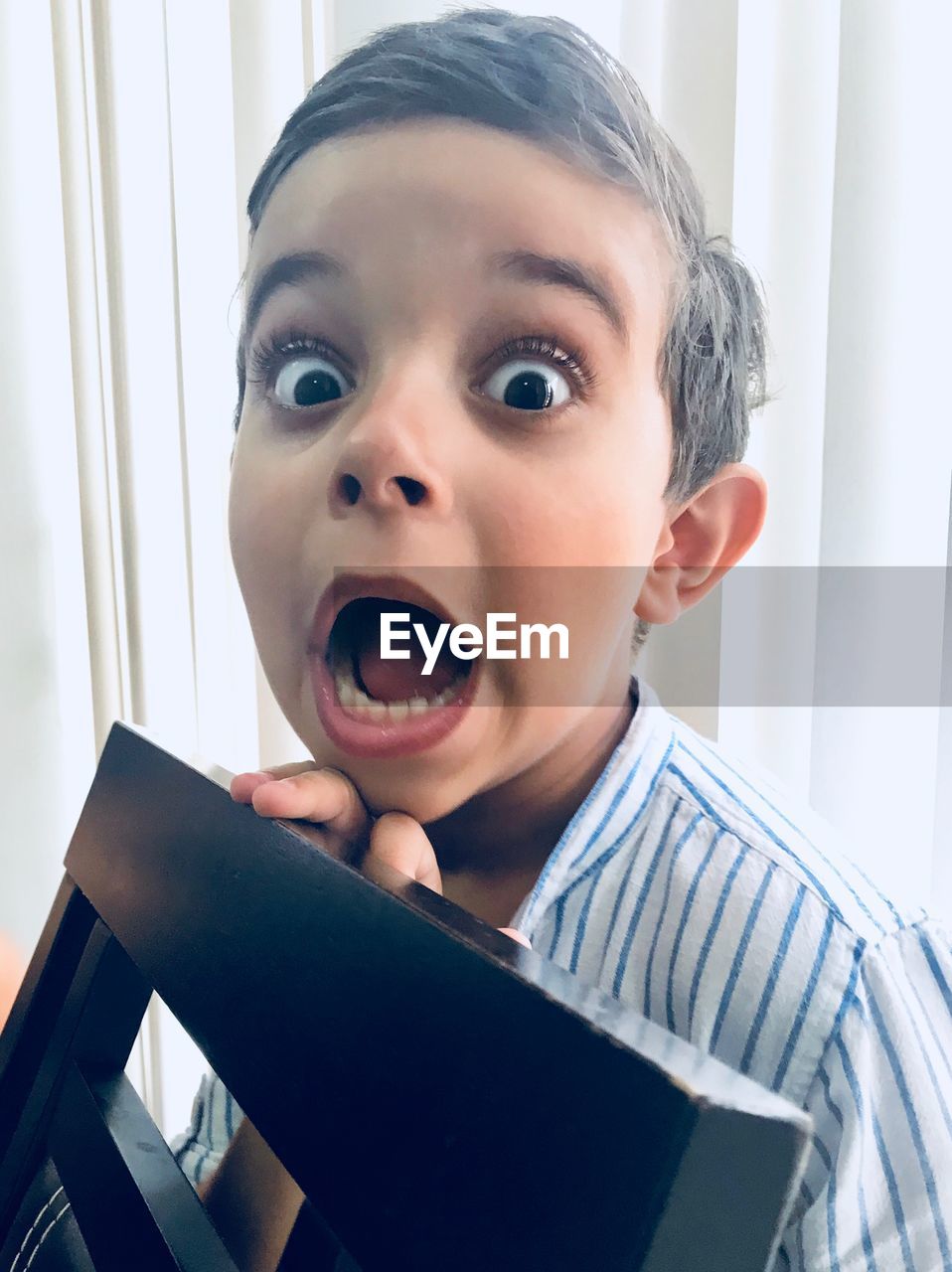 Portrait of boy with mouth open at home