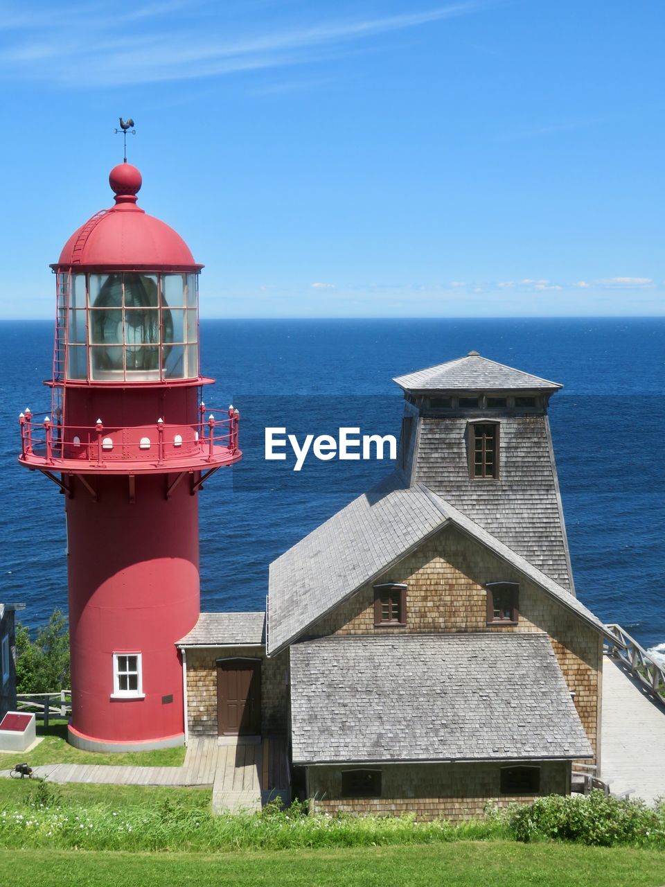 Lighthouse by sea against sky