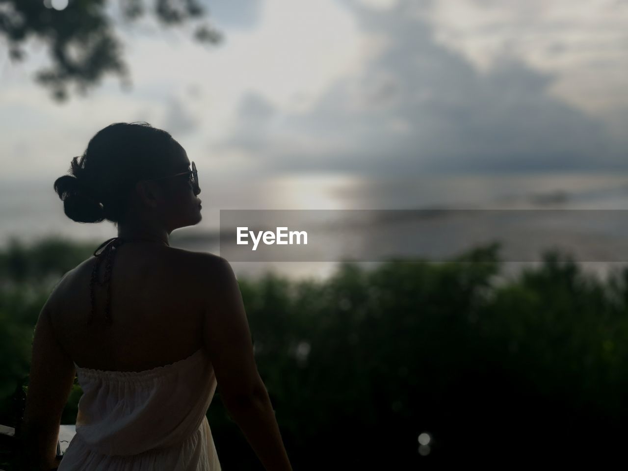 Woman standing against sea during sunset