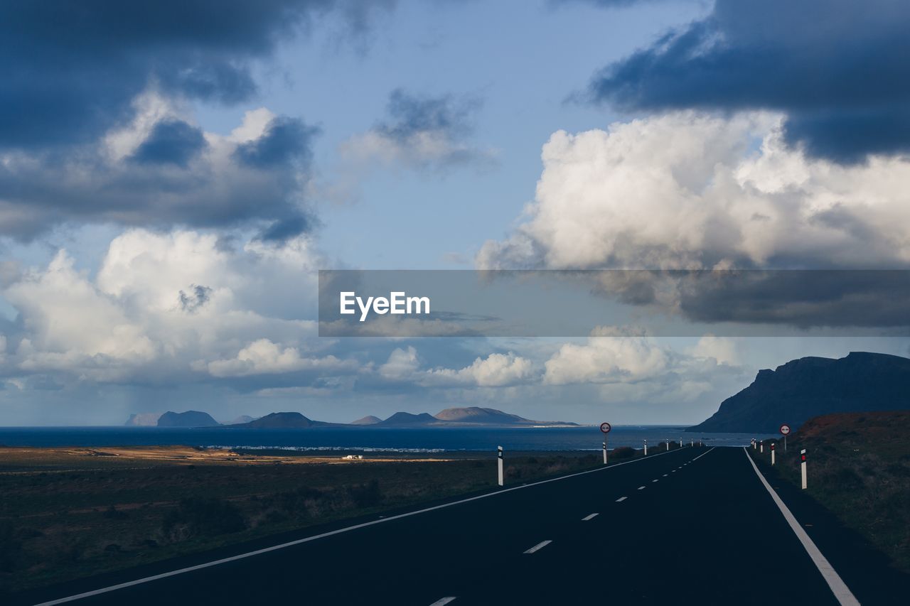 Road leading towards mountain against sky