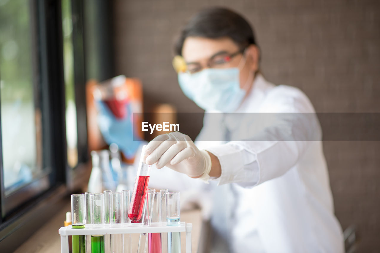 Doctor holding test tube over rack