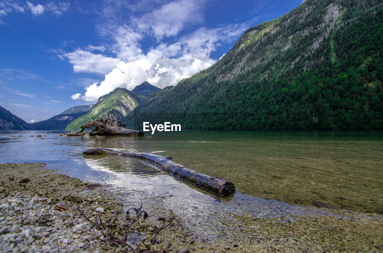 Scenic view of lake by mountain against sky