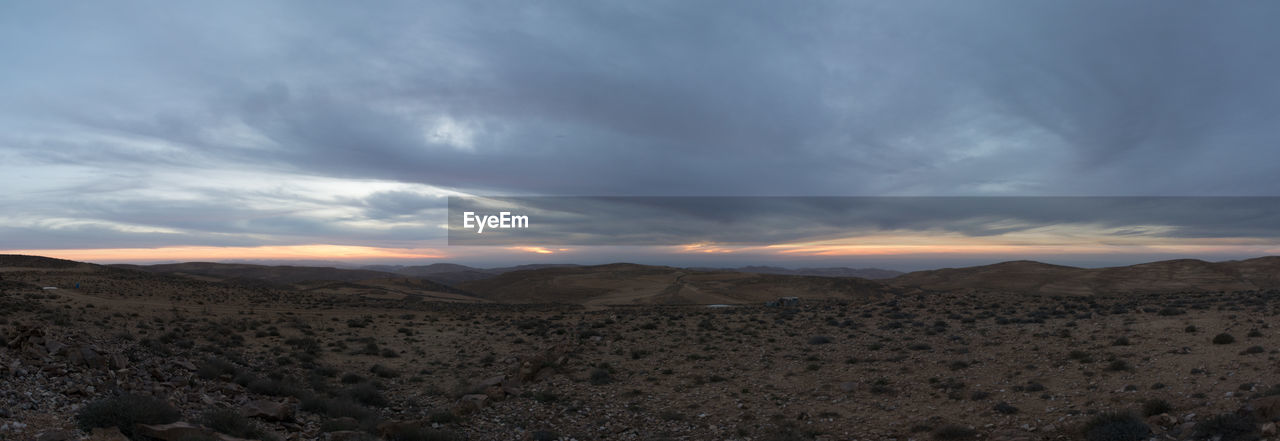 SCENIC VIEW OF ARID LANDSCAPE AGAINST SKY DURING SUNSET