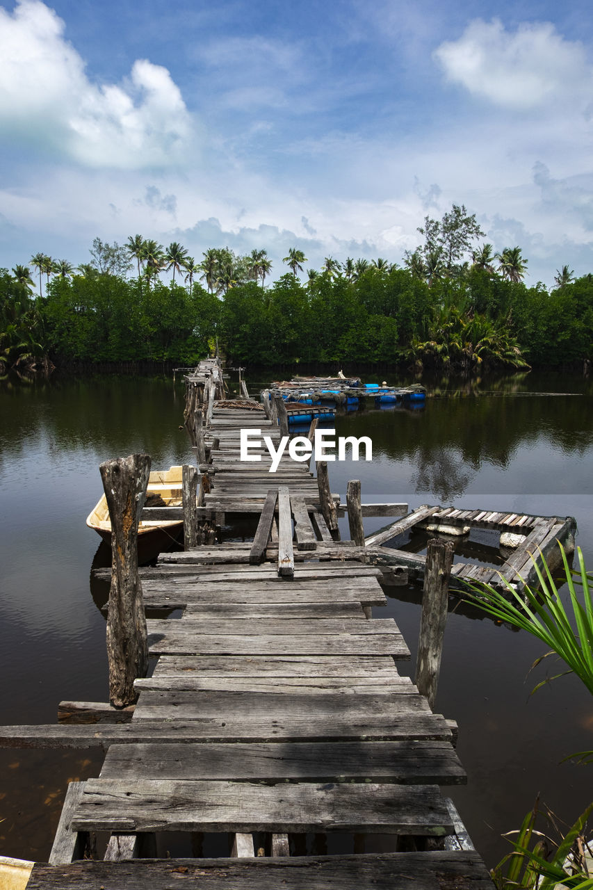 WOODEN PIER IN LAKE AGAINST SKY