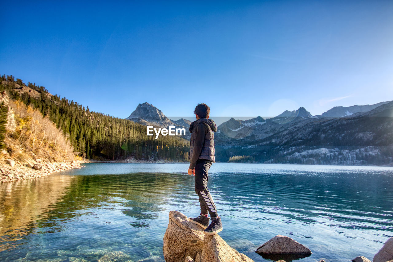 Boy looking over a lake in the sierras, california.