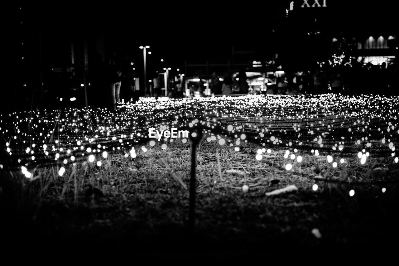Illuminated led lamp on field in city at night