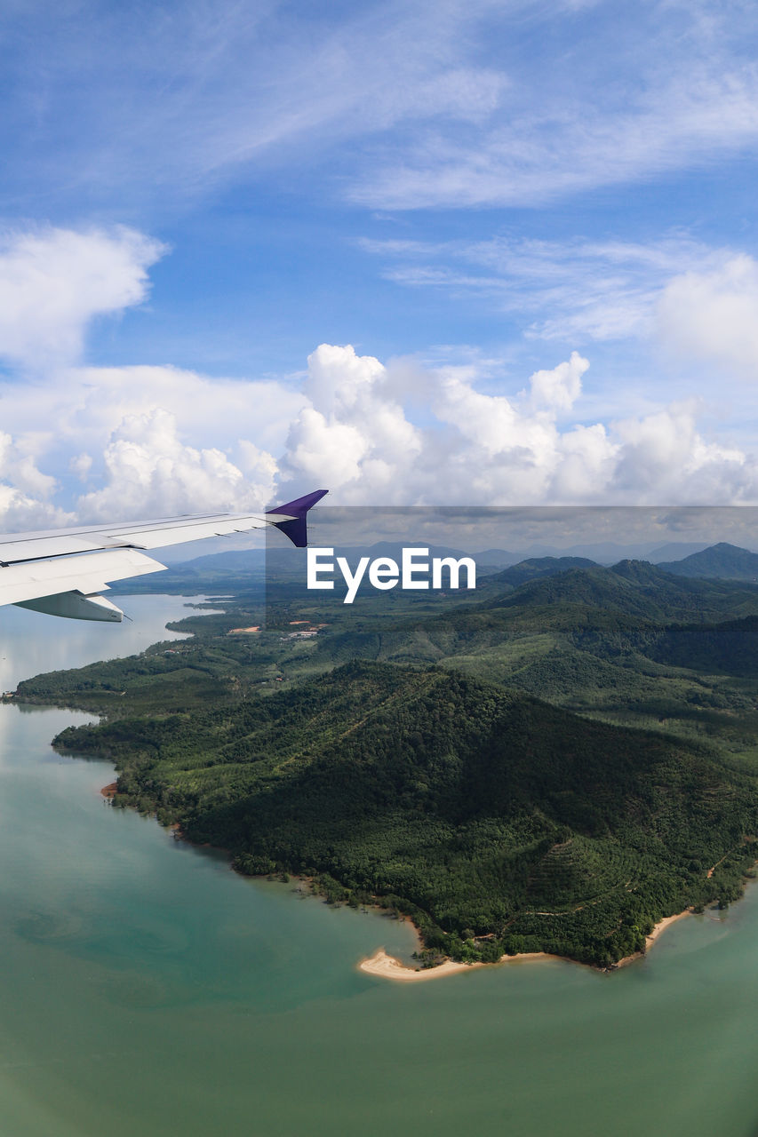 SCENIC VIEW OF AIRPLANE FLYING OVER LANDSCAPE AGAINST SKY