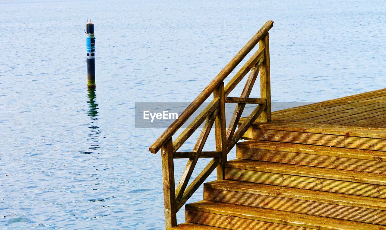 WOODEN POSTS ON PIER IN LAKE