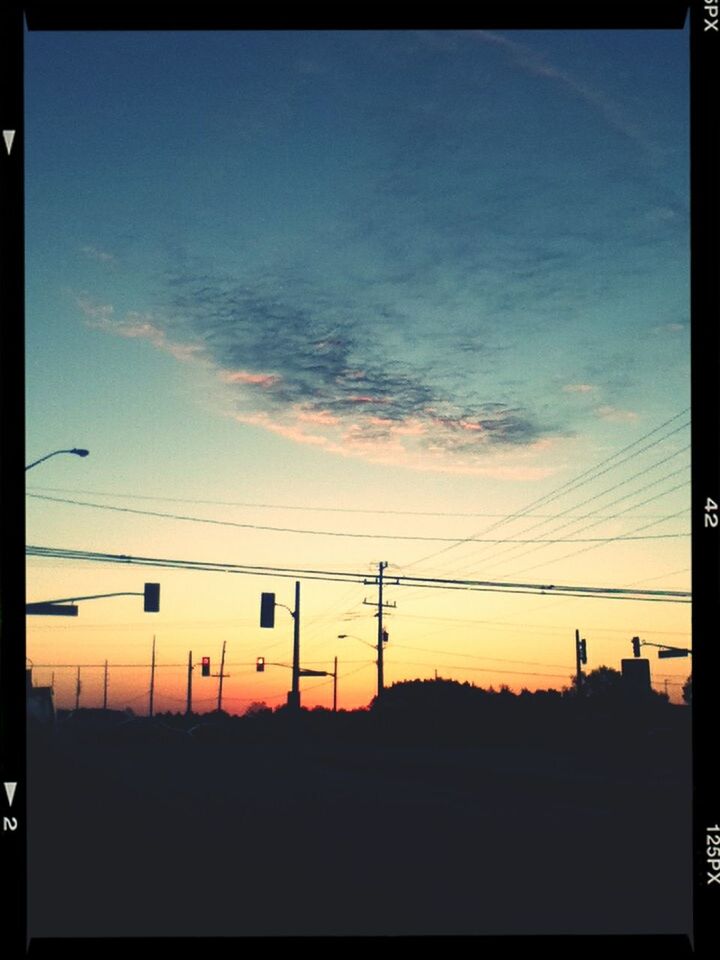 SILHOUETTE OF ELECTRICITY PYLONS AT SUNSET