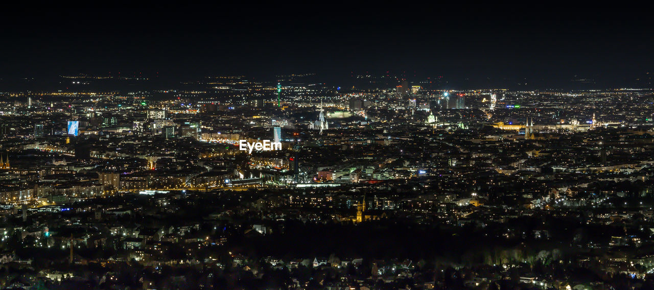 Illuminated cityscape against sky at night