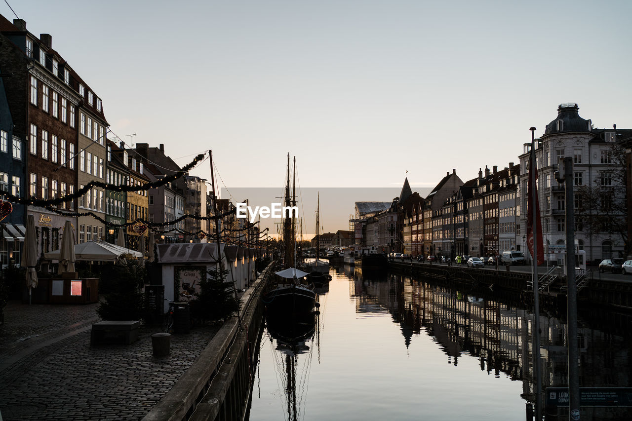architecture, cityscape, water, built structure, building exterior, reflection, sky, city, canal, evening, waterway, travel destinations, transportation, nature, building, nautical vessel, urban area, mode of transportation, clear sky, travel, tourism, street, bridge, body of water, history, the past, outdoors, dusk, town, no people, city life, sunset, waterfront, residential district