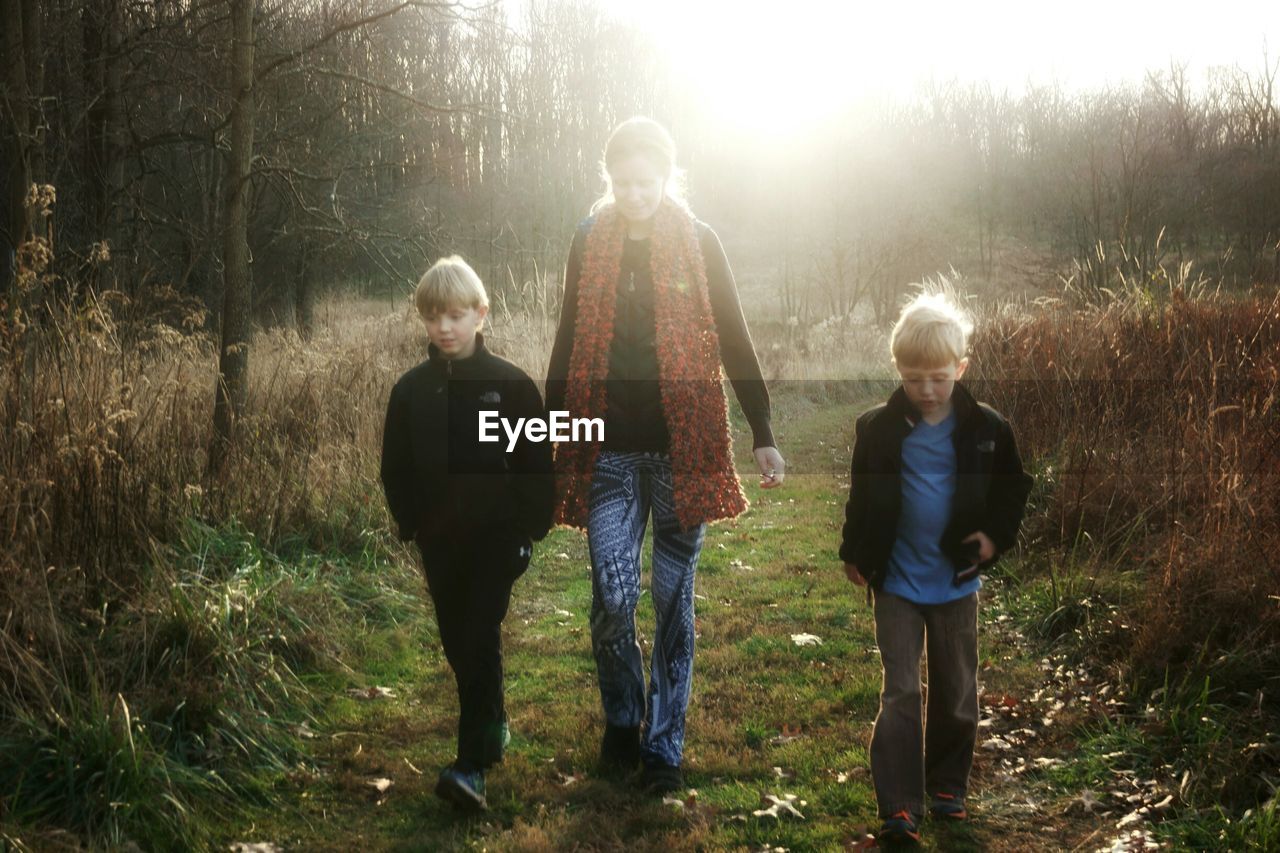 Mother walking with boys in forest