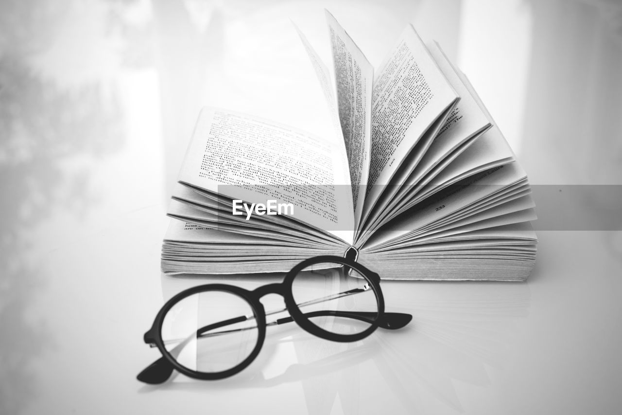 Close-up of eyeglasses and book on table