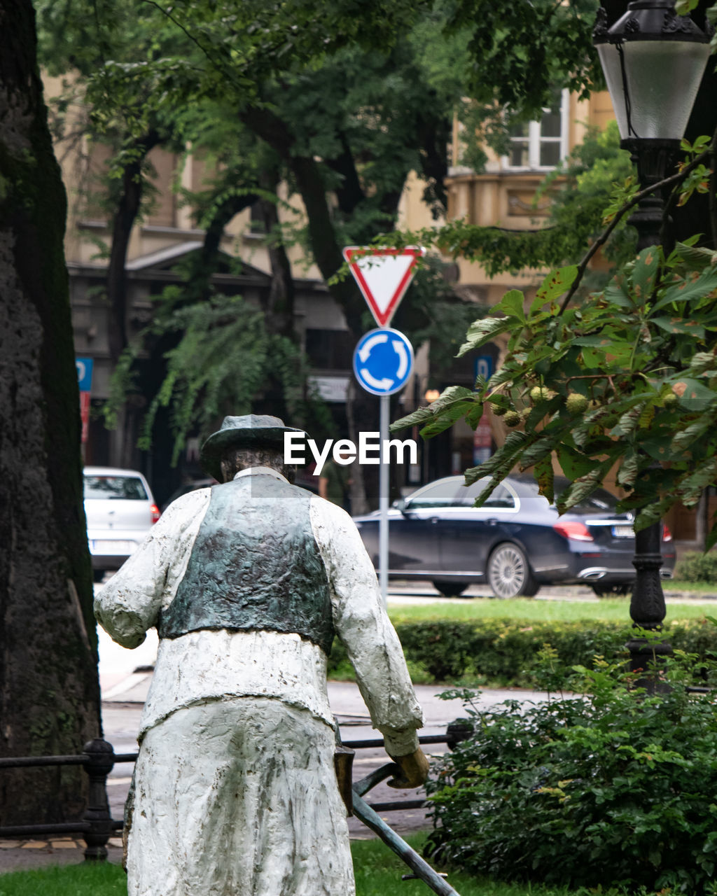 REAR VIEW OF MAN WALKING ON STREET