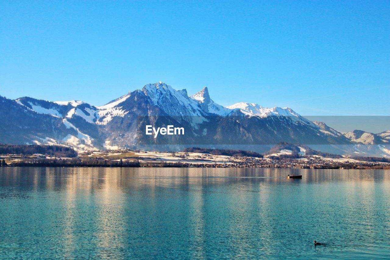 Scenic view of snowcapped mountains against clear blue sky